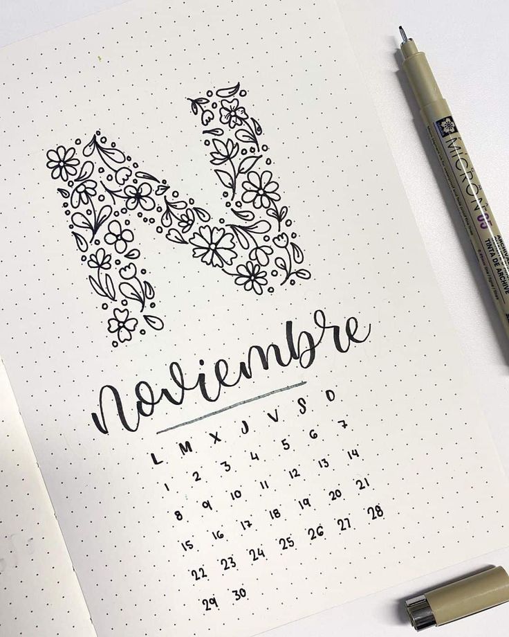 an open notebook with the word november written in cursive writing on it next to a marker