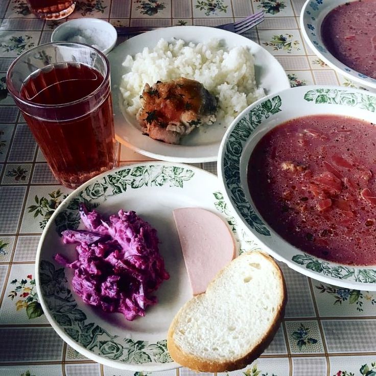 three plates with different foods on them sitting on a table next to cups and glasses