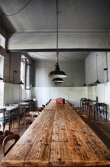 a long wooden table sitting in the middle of a room filled with tables and chairs