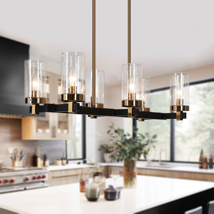 a kitchen with a large chandelier hanging from the ceiling next to a counter