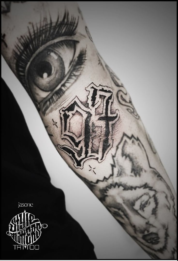 an eye and cross tattoo on the arm