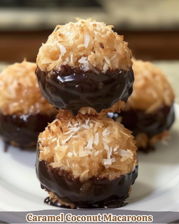 three chocolate covered donuts on a white plate with coconut flakes and shredded coconut