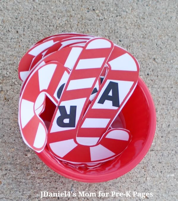 a red and white plate that has some stickers on it, sitting on the ground