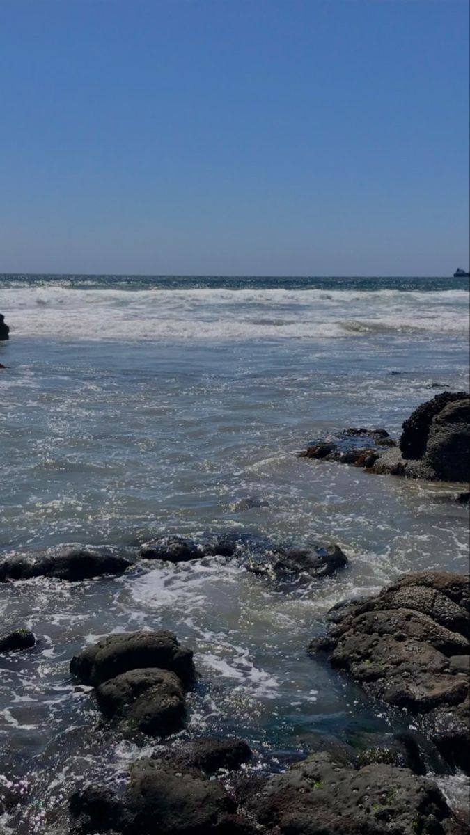 a person riding a surfboard on top of a body of water near the shore