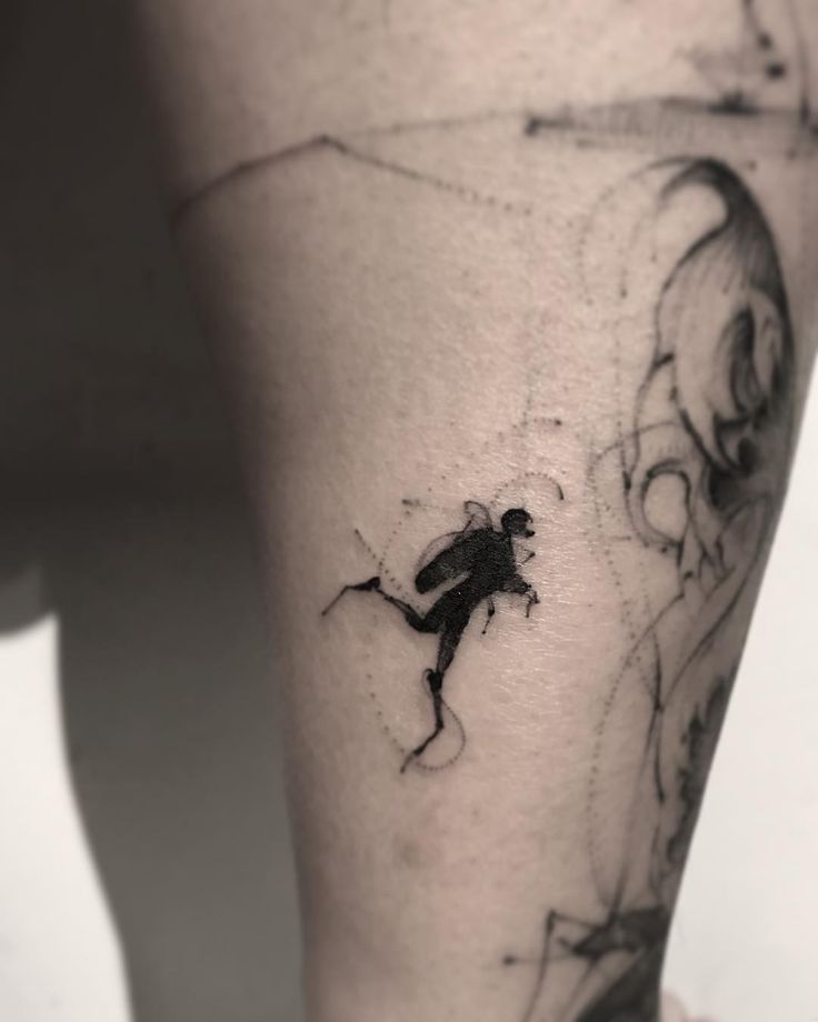 a black and white photo of a person's leg with a tattoo on it