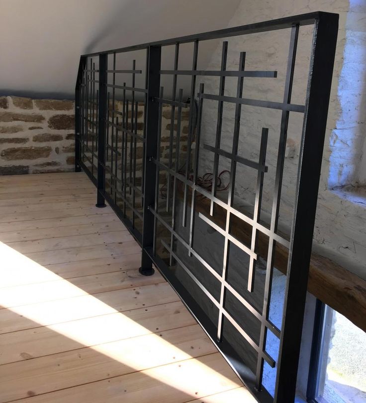 a room with wooden floors and metal railings