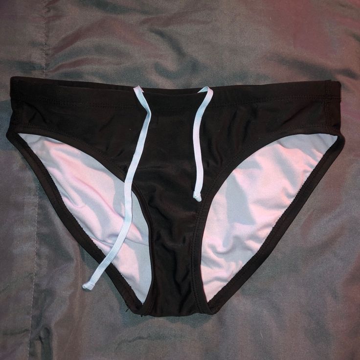 Size Small Champion Bikini Bottoms With A Tie-Able Waist Band. Never Worn Fitted Swim Trunks With Tie-side Bottom, Fitted Tie-side Bottom Swim Trunks For Swimming, Fitted Swim Trunks For Water Polo, Fitted Brief Swim Trunks For Water Polo, Fitted Water Polo Swim Trunks Brief, Black Beachwear Swim Trunks For Pool, Black Stretch Swim Trunks For Beach Season, Black Swim Trunks For Poolside And Beach Season, Black Bottoms For Sunbathing Beach Season