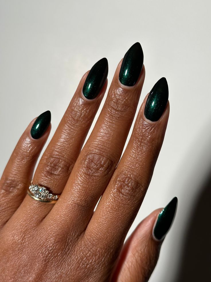 Dark emerald green shimmer 10-free. Vegan. Cruelty-free. Nontoxic. We suggest using a base coat and 2-3 coats of polish followed by a top coat. This polish comes with a removable handmade decorative bronze cap atop our standard black matte nail polish cap - merging artistry with function. To forego bronze caps on your order click here. Swatches by @eviltwinnails @polish.d_ @melly.k.nails @melanted.mani Simple Prom Nails Emerald Green, Deep Emerald Green Nails, Dark Jewel Tone Nails, Opi Dark Green Nail Polish, Dark Green Nails Sparkle, Black Nails With Green Chrome, Dark Shimmer Nails, Dark Green Metallic Nails, Dark December Nails