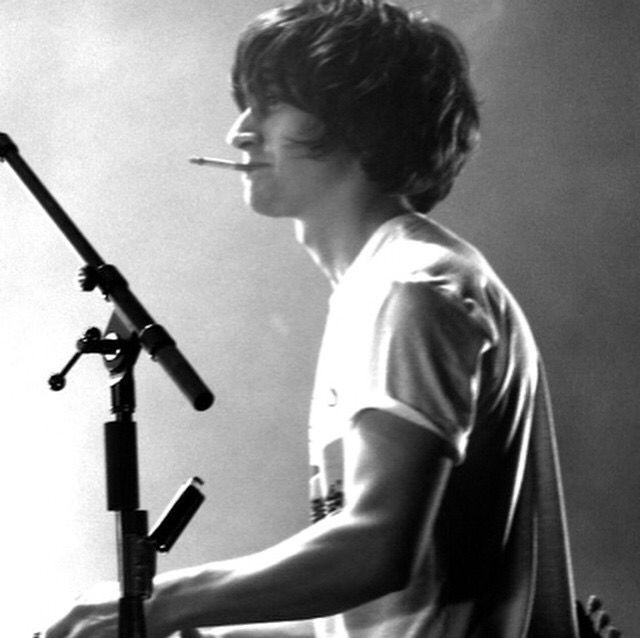 a young man is playing the keyboard in front of a microphone