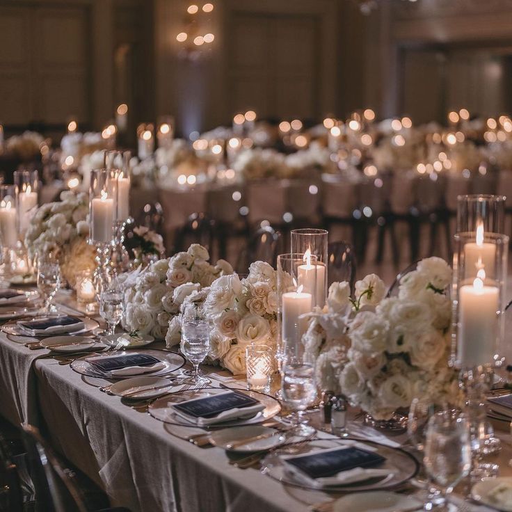 a long table is set with white flowers and candles for an elegant wedding reception at the four seasons hotel