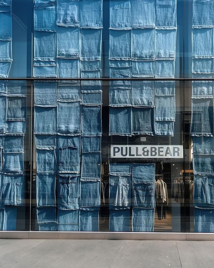 an image of a store front with blue jeans on display in the window and behind it is a sign that says pull & bear