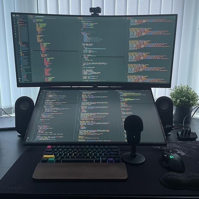 a computer monitor sitting on top of a desk next to a mouse and headphones