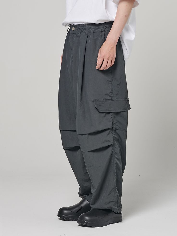 Editor's notesWide Parachute Balloon Pants by AKECII are made of 100% nylon and feature a relaxed fit with waist pleats, allowing for a wide fit styling. They have unique flap cargo pocket details and knee pleats as distinctive features. These pants are suitable for both men and women.- Wide and relaxed fit- Elastic waistband- Drawstring with stopper at the hem- Flap cargo pockets- Unisex available- Versatile itemMeasurements(in.)M / L- Length: 38.58 in. / 39.76 in.- Waist: 11.81 in. / 12.60 in. Functional Gray Bottoms With Cargo Pockets, Gray Utility Parachute Pants With Multiple Pockets, Gray Nylon Bottoms With Pockets, Baggy Gray Parachute Pants With Multiple Pockets, Functional Gray Cargo Pants, Functional Gray Cargo Bottoms, Gray Relaxed Fit Parachute Pants With Elastic Waistband, Gray Relaxed Fit Parachute Pants With Side Pockets, Gray Relaxed Fit Cargo Parachute Pants