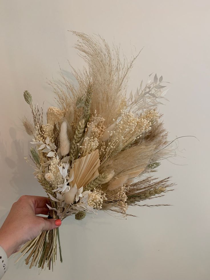 a person is holding some dried flowers in their hand