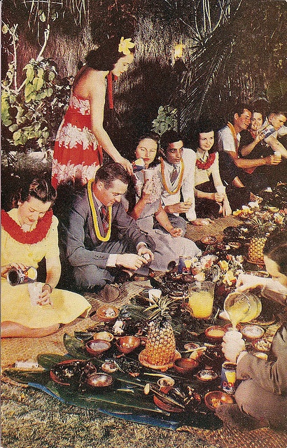 a group of people sitting around a table with food on it