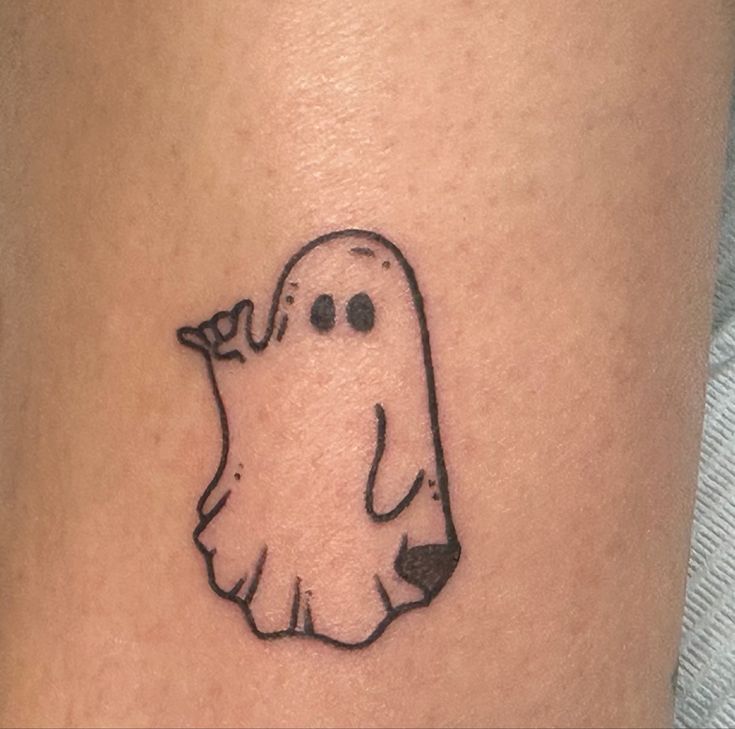 a small ghost tattoo on the leg