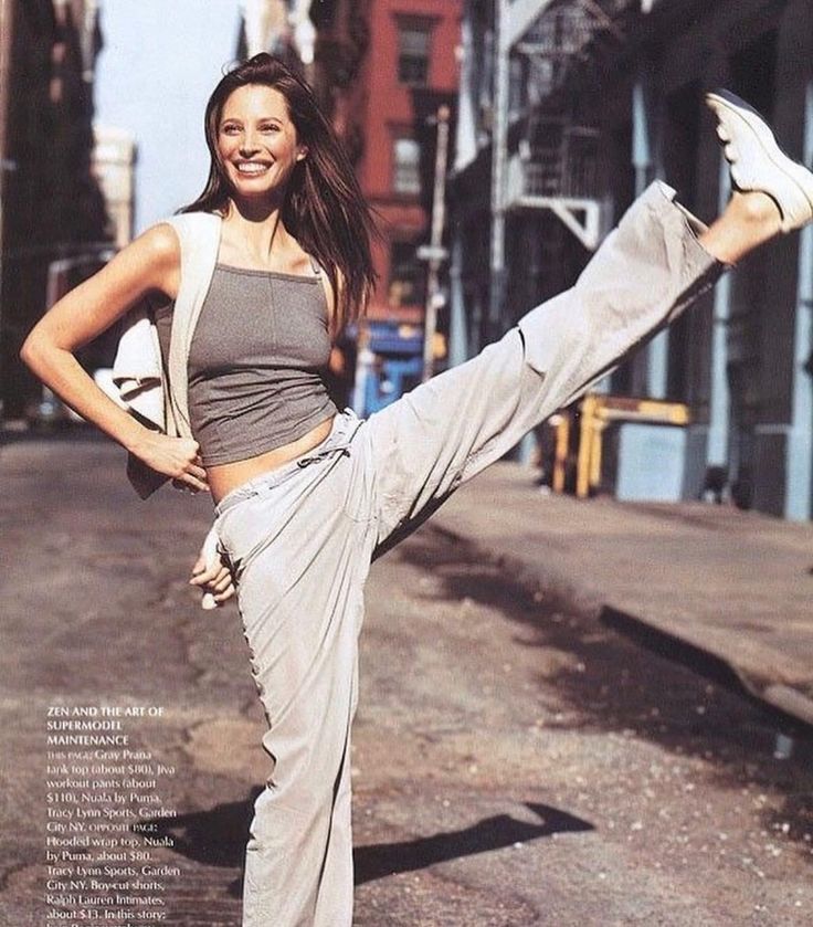 a woman standing on one leg in the street