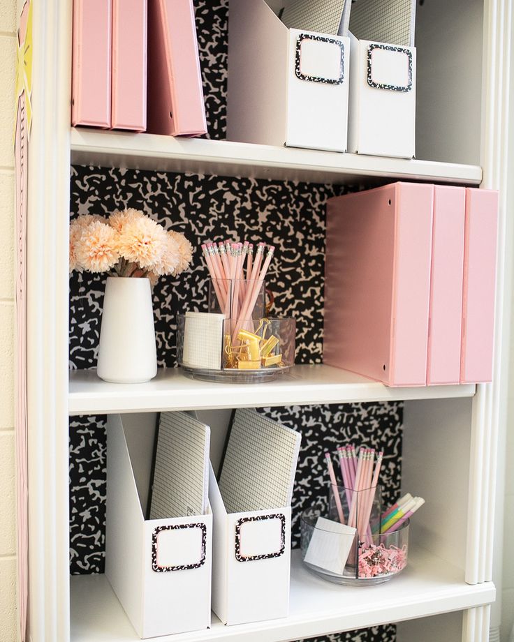 the shelves are organized with pink and white storage bins, paper straws, and other office supplies