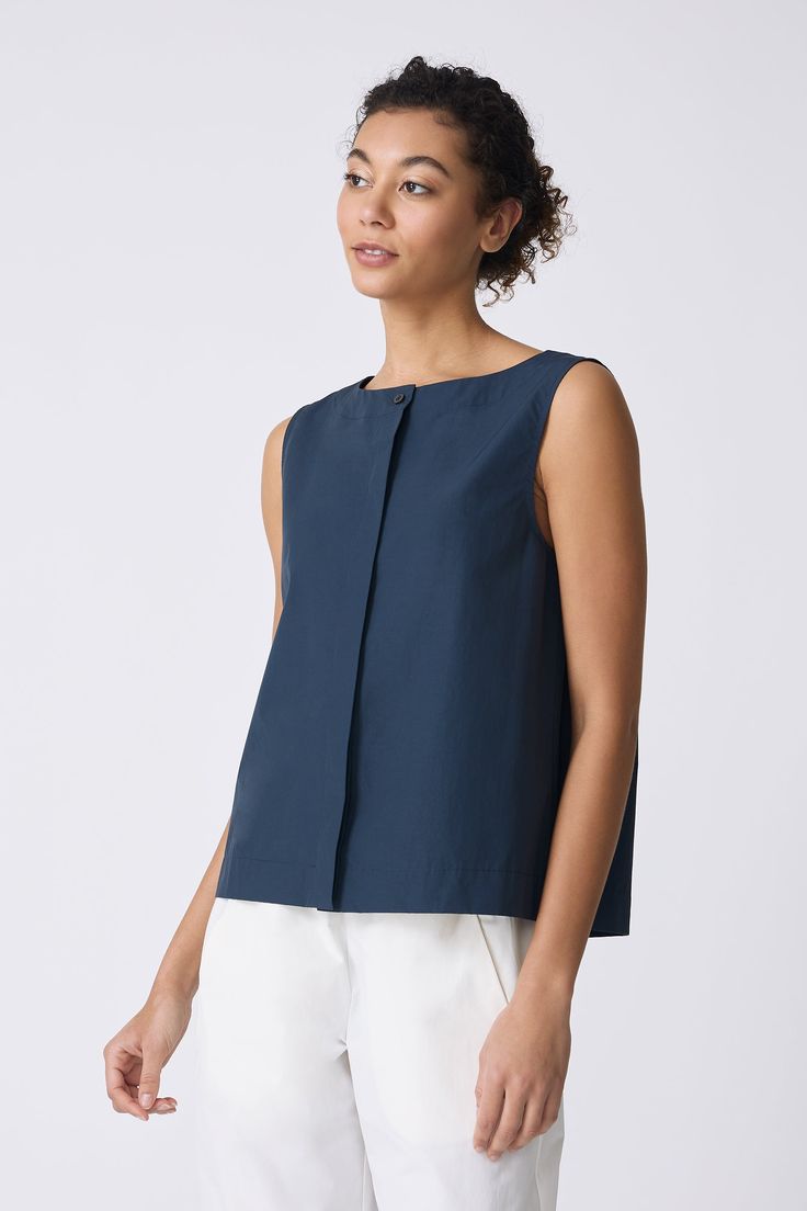 Sweet and simple, our Colette Shell is the perfect Spring into Summer top. With a boatneck shape, this charming top will soon be your bestie. Boat neck style with stitch down facing, center front hidden placket with top button exposed, back inverted pleat with stitch detail, wide finish hem - 51% Cotton, 49% Nylon - Fabric woven in Italy - Made in NYC - Dry clean or machine wash - Our model is 5'9" wearing size S - Chest 39", Hip 42", Length 23" Orders are processed within three business days (n Sleeveless Tops With Back Button Closure For Spring, Cotton Workwear Top With Button Back, Sleeveless Tops For Work With Back Button Closure, Classic Spring Tops With Button Back, Sleeveless Spring Top With Button Back, Sleeveless Button Back Top For Spring, Sleeveless Tops With Button Back For Spring, Spring Sleeveless Top With Button Back, Spring Button Back Tops For Work