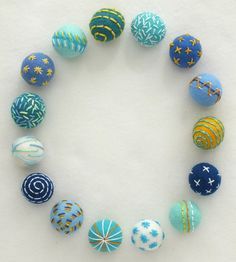 an arrangement of painted eggs arranged in a circle on a white surface with stars and swirls