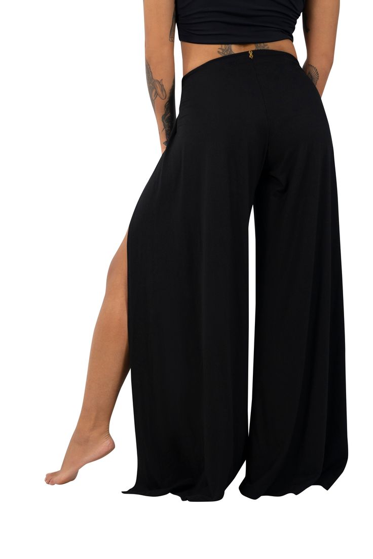 The Paris palazzo pants walk the line between covered and cool with a drapey wide leg and split front. These resort wear inspired wrap pants give your look a classy yet casual vibe that you can dress up or down depending on your mood or location. FEATURES: No fuss, stretchy & easy to pull on High front slits Flowy wide leg silhouette Mid rise Preshrunk Available size XS-3XL Crafted from 93% Lenzing certified TENCEL™ (a sustainable fabric made from eucalyptus trees) and 7% spandex (which we offse Evening Full Length Bottoms With Side Slits, Chic Wide-leg Yoga Pants, Black Wide Leg 4-way Stretch Yoga Pants, Black Wide Leg Yoga Pants With 4-way Stretch, Chic High-waisted Wide Leg Pants With Side Slits, Wide Leg Bottoms With Side Slits For Evening, Elegant Yoga Pants, Chic Yoga Pants, Black Full-length Pants With Side Slits