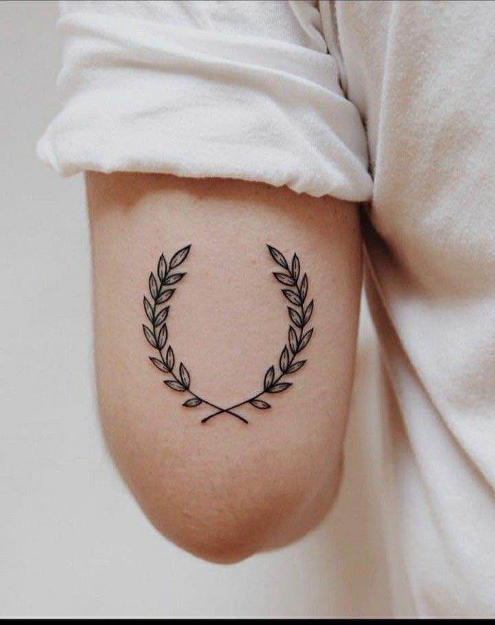 a person with a tattoo on their arm and the word love is written in a wreath