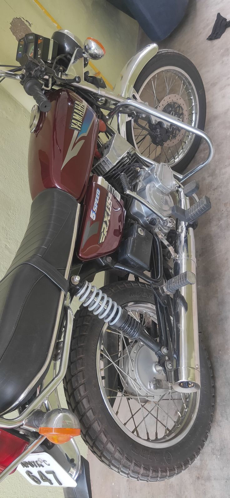 a red motorcycle parked in a garage next to a wall