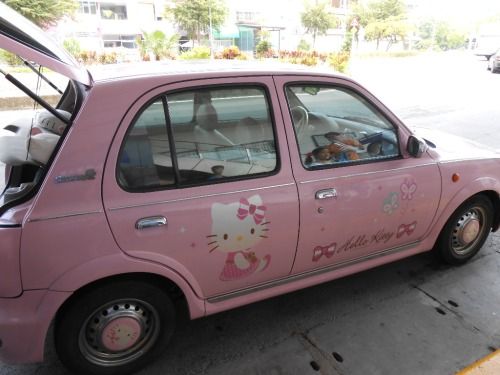 a pink car with hello kitty painted on the side