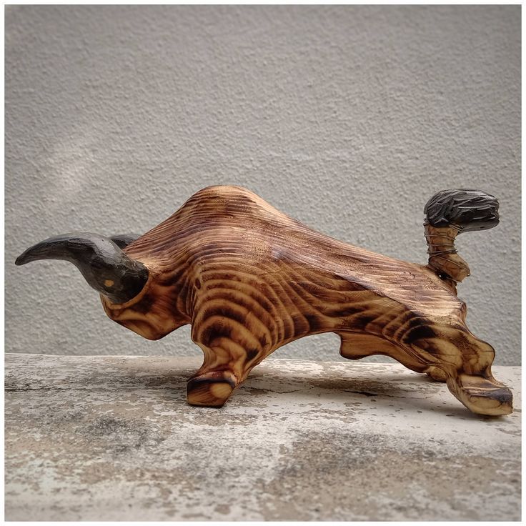 a wooden sculpture of an animal with long horns