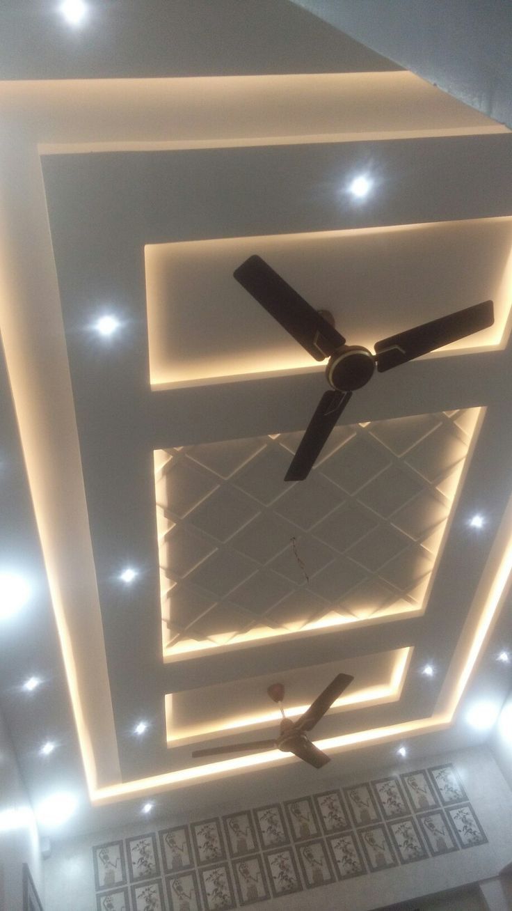 a ceiling with lights and a fan in the middle is lit up by dim lighting