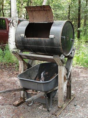 an old fashioned bbq grill sitting in the woods