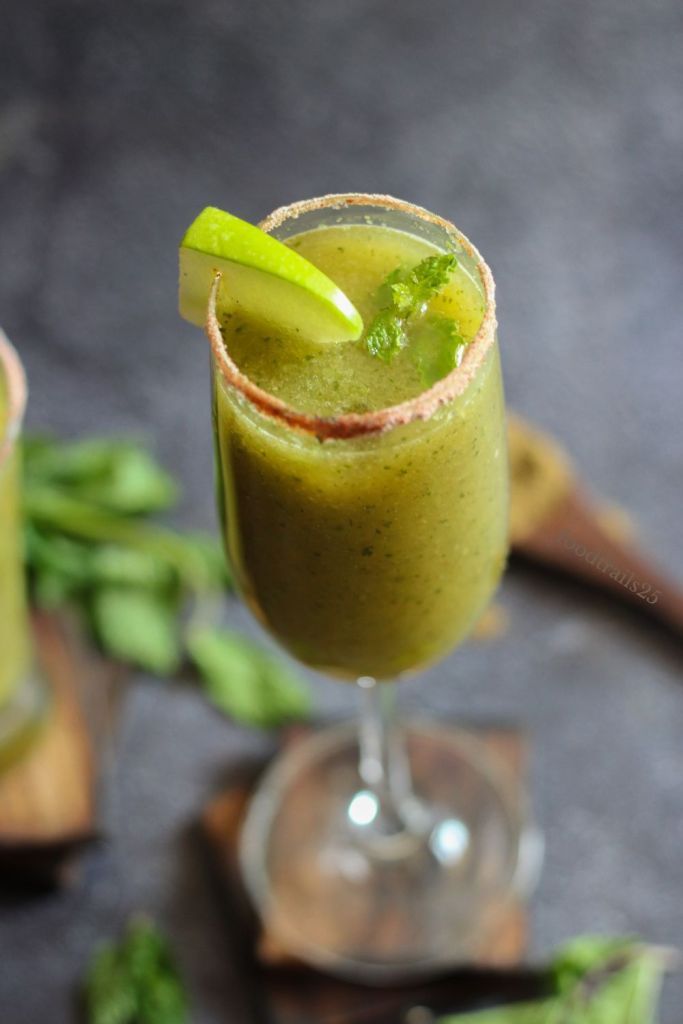 two glasses filled with green smoothie and garnished with lime