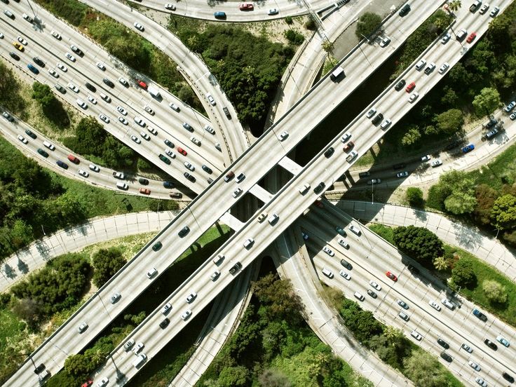 an aerial view of multiple roads and lanes in the middle of a highway with trees on both sides