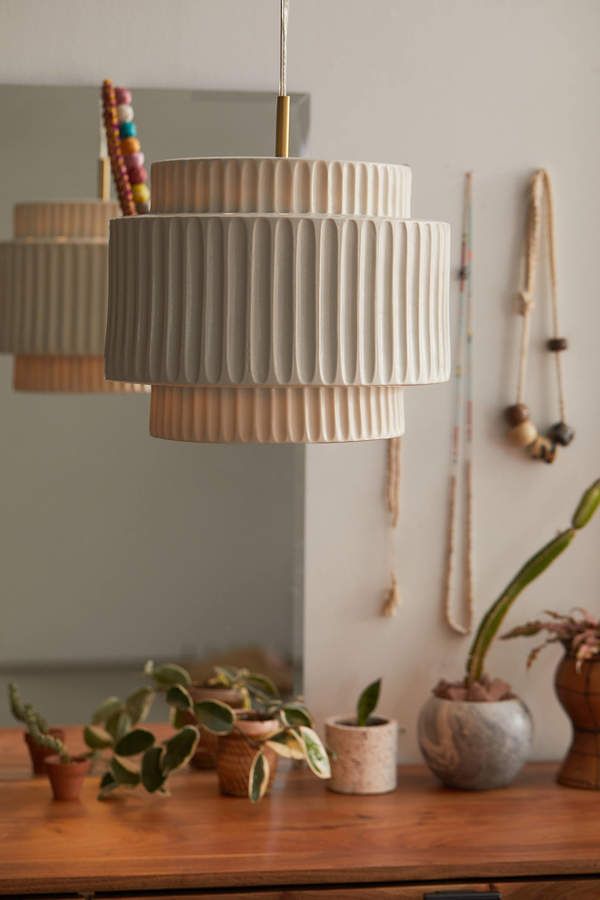 a wooden table topped with lots of plants next to a wall mounted light hanging from the ceiling