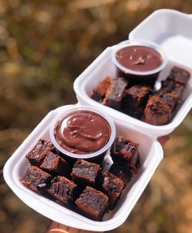 two plastic containers filled with brownies and dipping sauces on top of each other