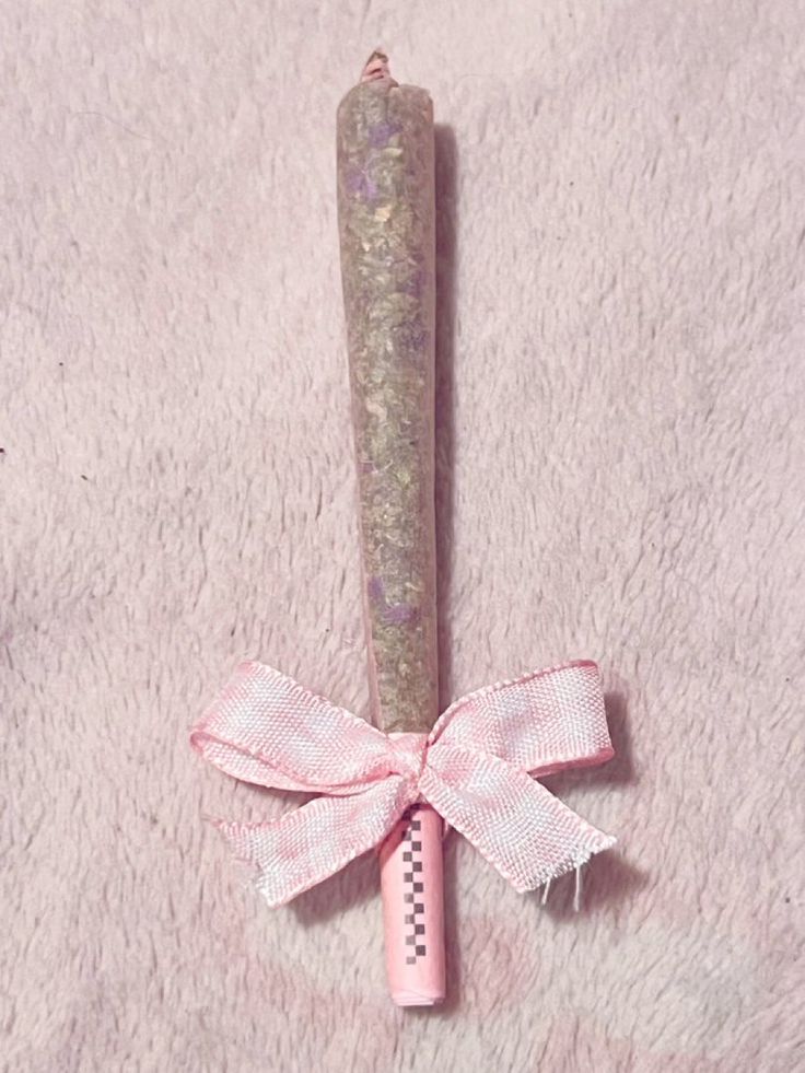 a pink pen with a bow on it sitting on top of a white carpeted floor