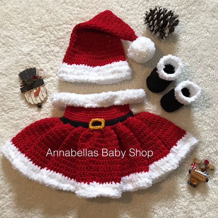 a crocheted santa claus outfit with matching hat and booties is laying on the floor