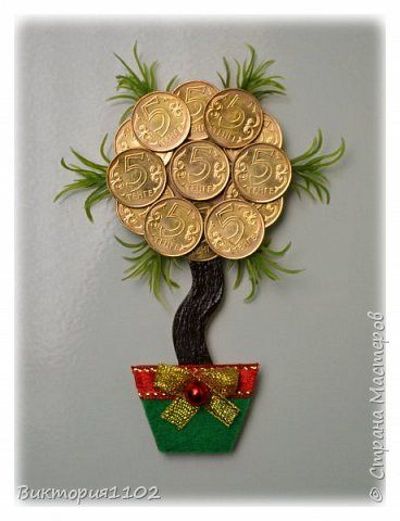 a tree made out of gold coins sitting on top of a green potted plant