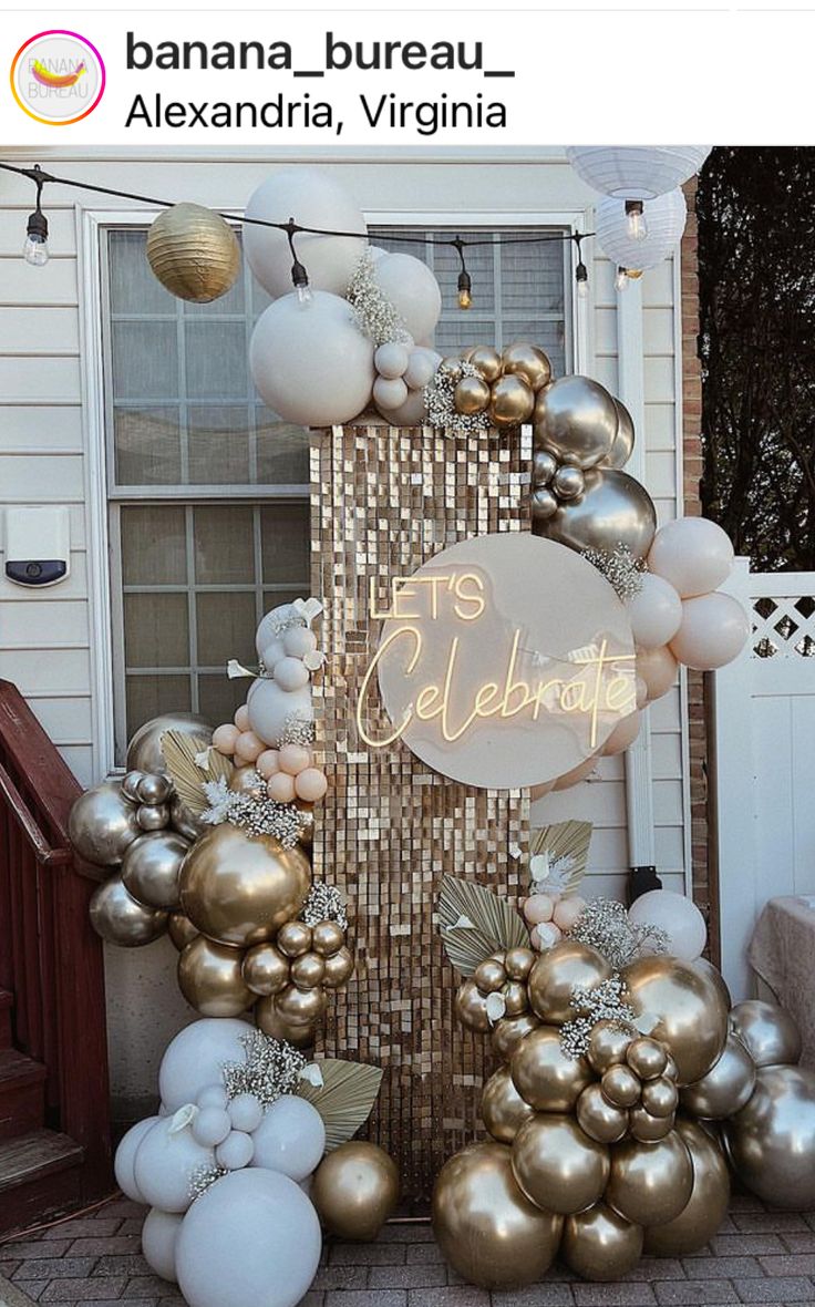 an outdoor display with balloons and lights on the side of a house that says celebration