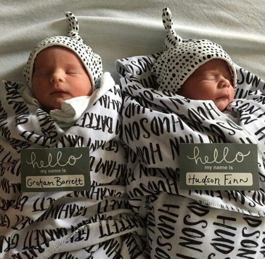 two newborn babies wrapped in blankets with name tags