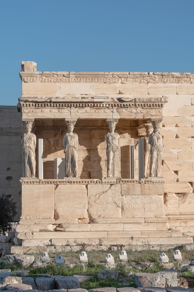 some statues on the side of a building with no people around them or in front of it