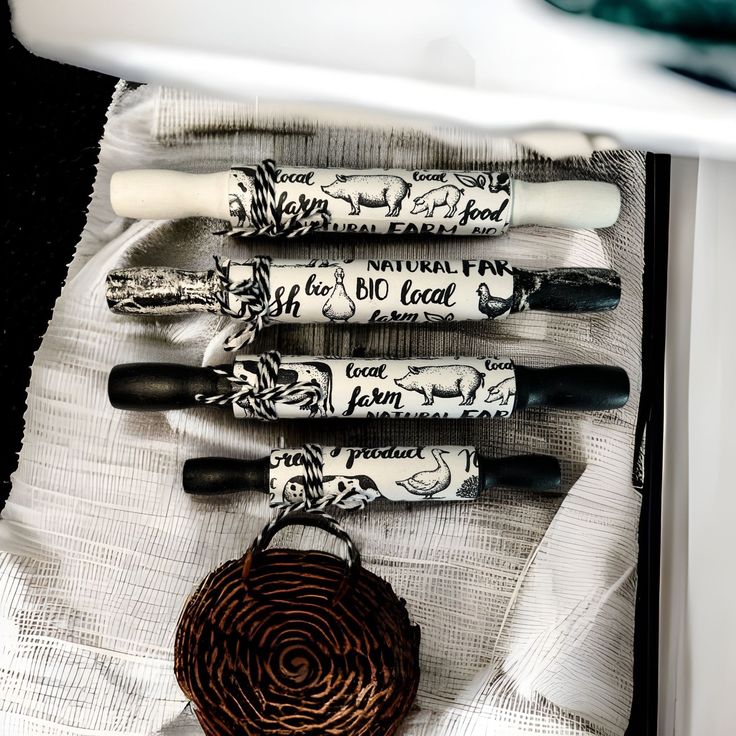 four pens are lined up in a row next to a bowl and napkins on a table