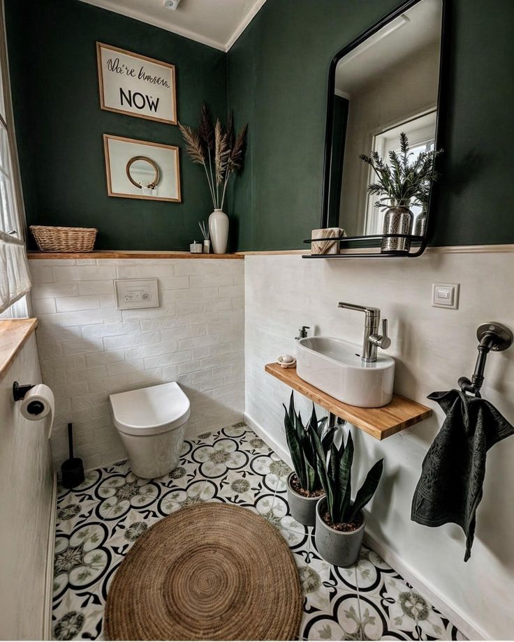 a bathroom with green walls and white tile flooring, potted plants on the counter