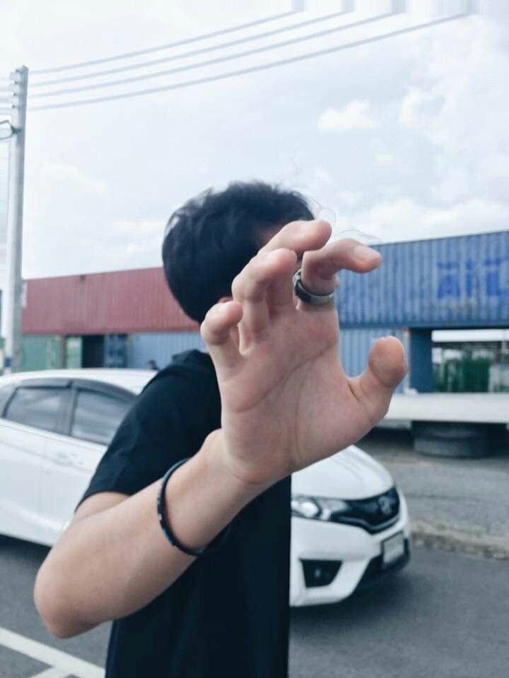 a man making the vulcan sign with his hand while standing in front of a car