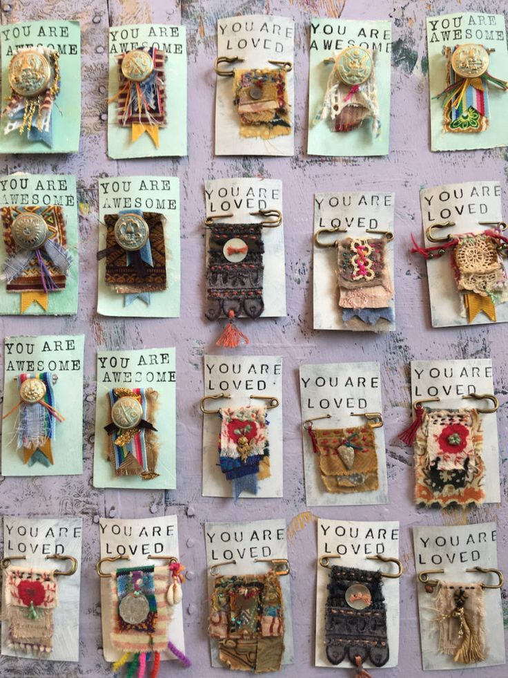 there are many different types of brooches hanging on the wall with words that say you are loved