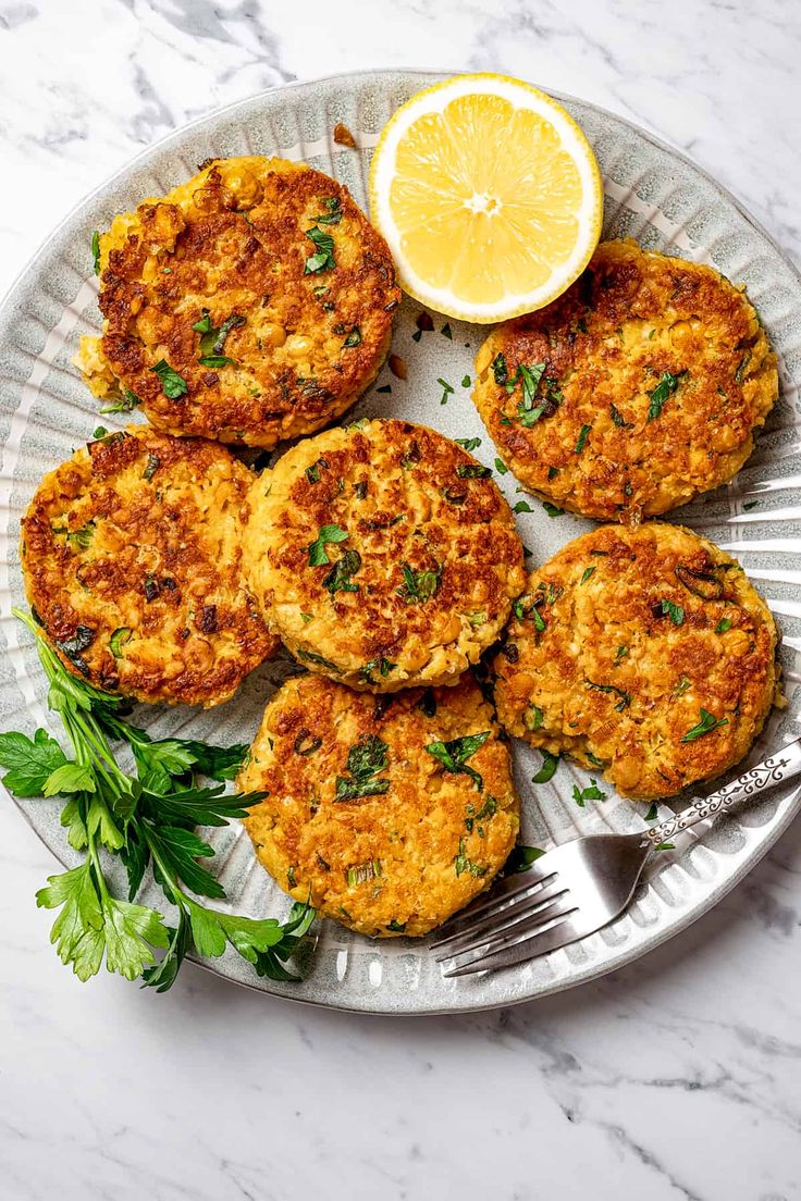 crab cakes on a plate with lemon wedges