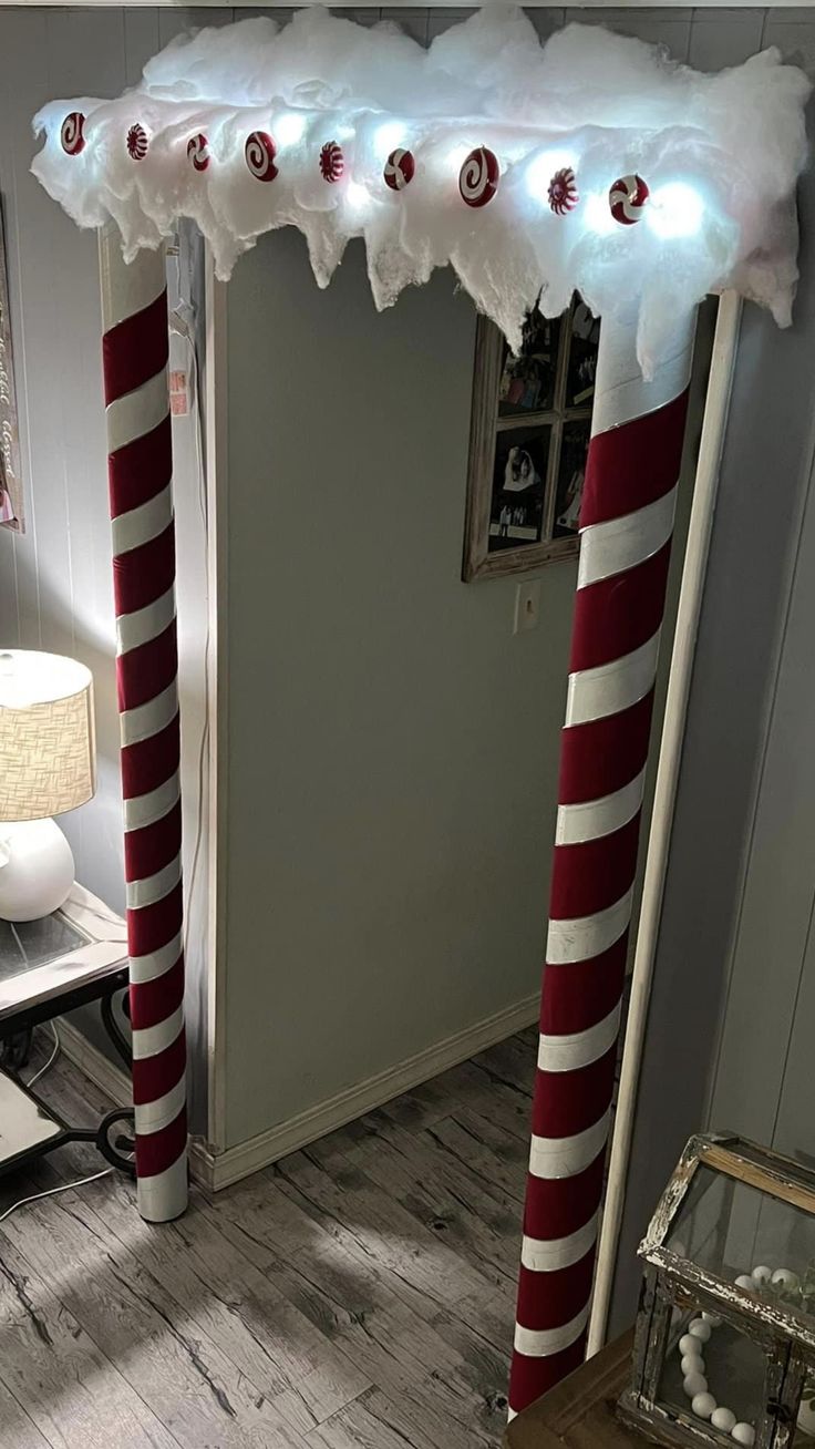 a room decorated for christmas with lights and candy canes on the door pole, along with other decorations