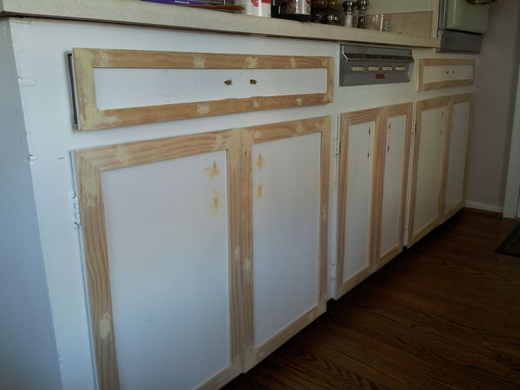 an unfinished kitchen with white cabinets and wood trim