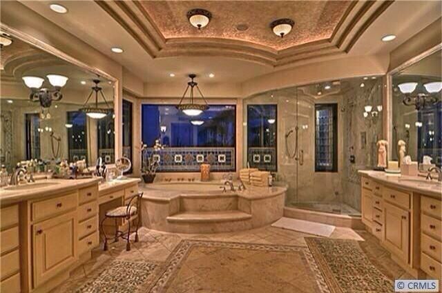 a large bathroom with two sinks and a bathtub in the middle of the room