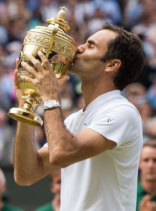 a male tennis player is kissing the trophy